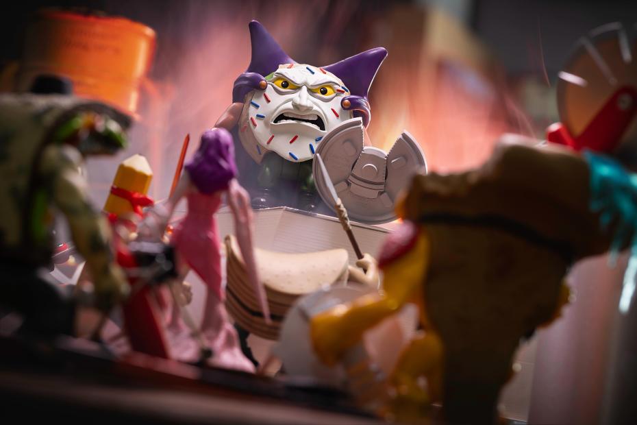 Major Custard figure raising a shield in a 9 to 5 Warriors breakroom battle