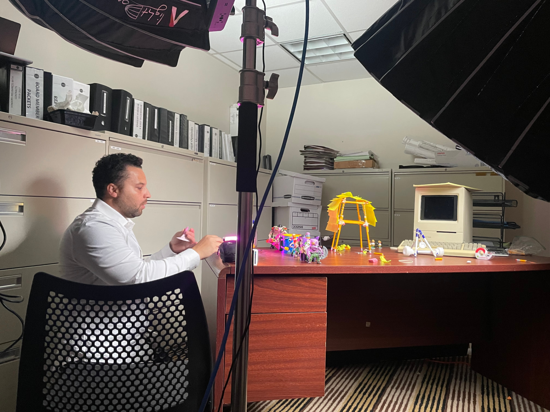 Brandon Braswell setting up a miniature office desk scene for 9 to 5 Warriors